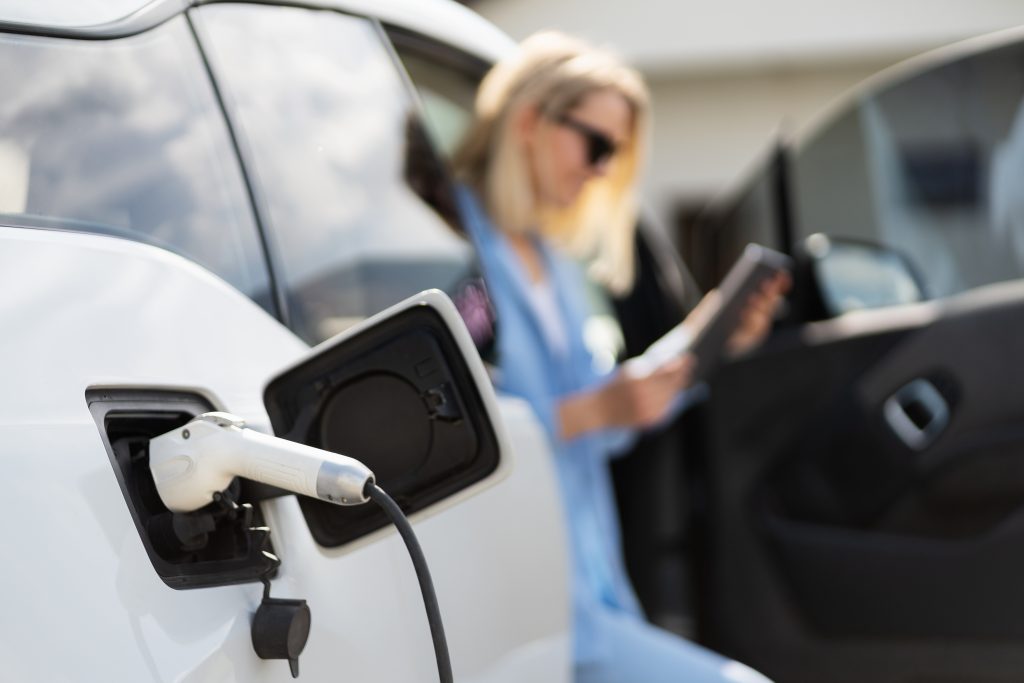 Pro Auto Repair Marketing Strategy Tips In 2026 For Revving Up Business 20 woman charging electric car and using smartphone o 2025 03 09 13 24 44 utc